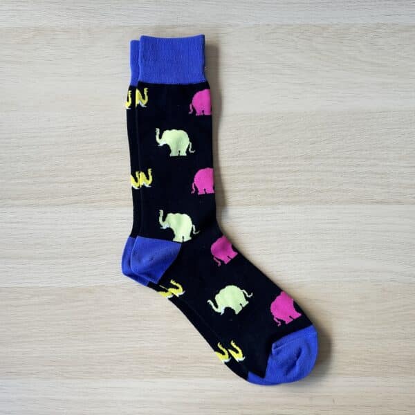 black sock with blue and pink elephants on them. facing right