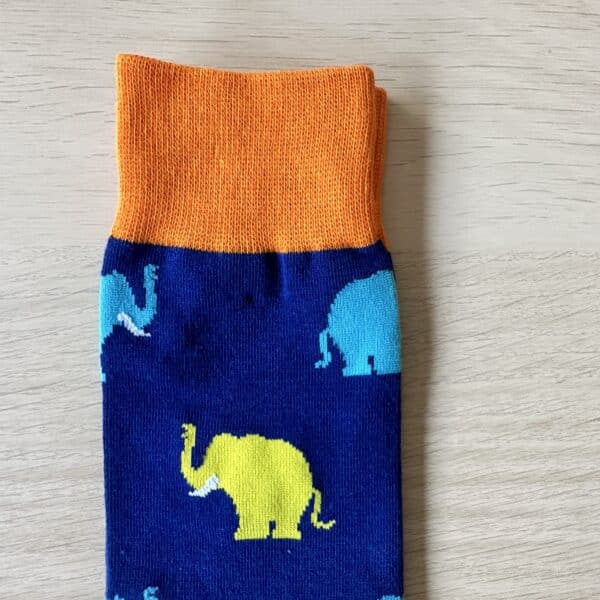 blue sock with blue and yellow elephants on them . close up image