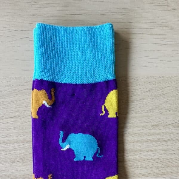 purple sock with blue and yellow elephants on them . Close up