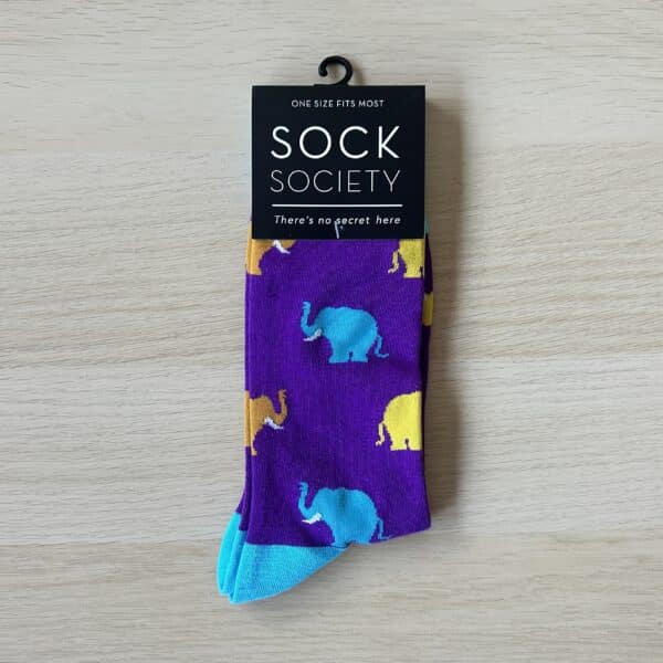 purple sock with blue and yellow elephants on them with a sock society label