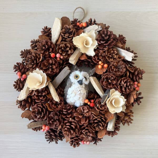 Wreath made up of cones with berries and an owl in the centre